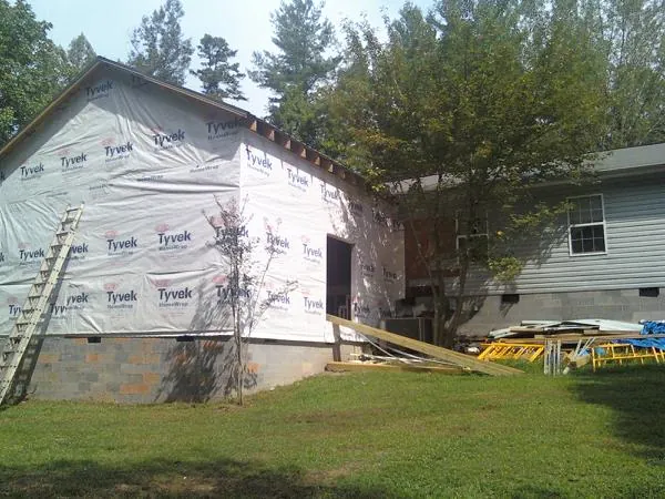Tyvek wrapped gable on a new room addition beside an existing home in Upton